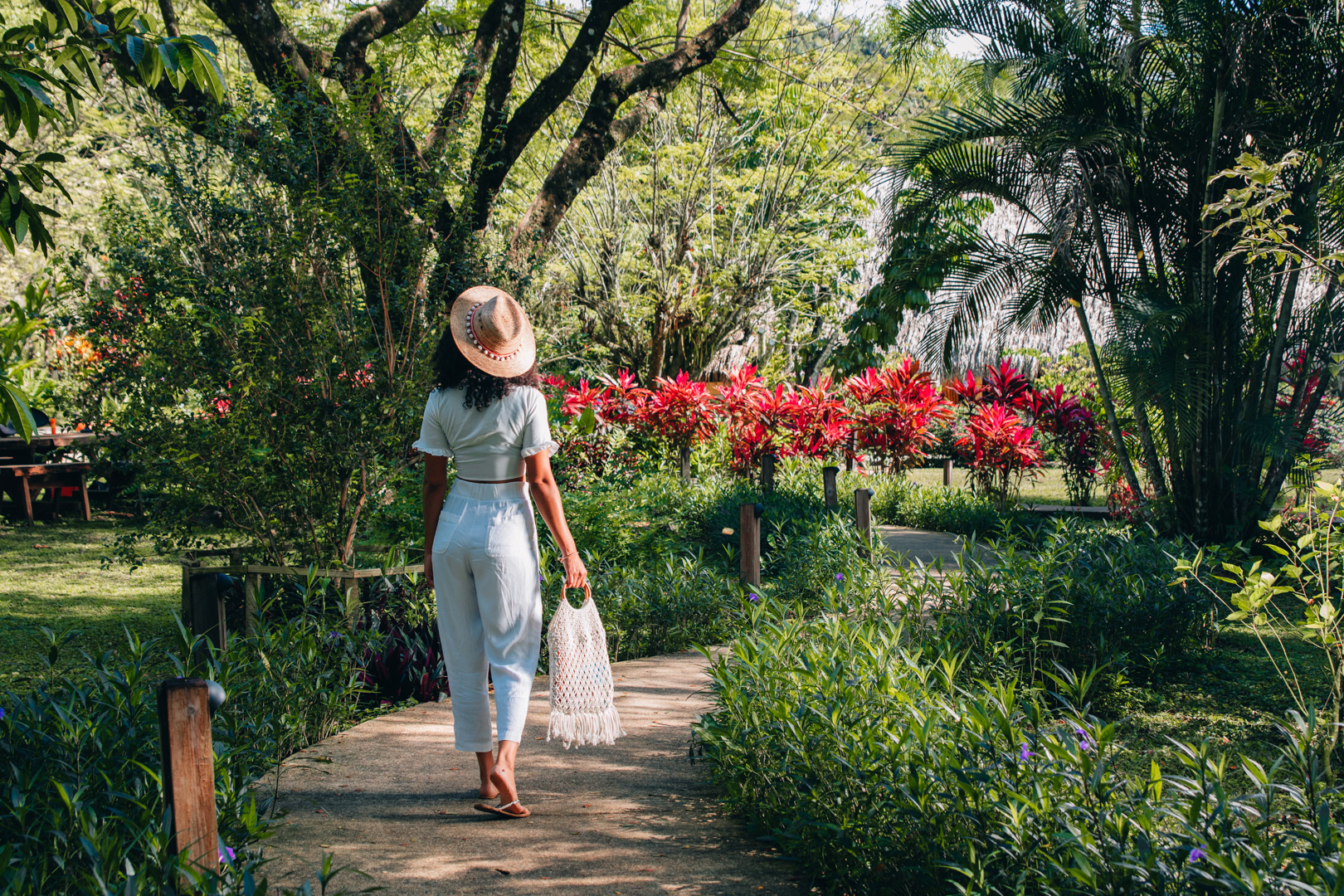 A guest walking on the sidewalk through a landscaped garden at the Rainforest Lodge at Sleeping Giant