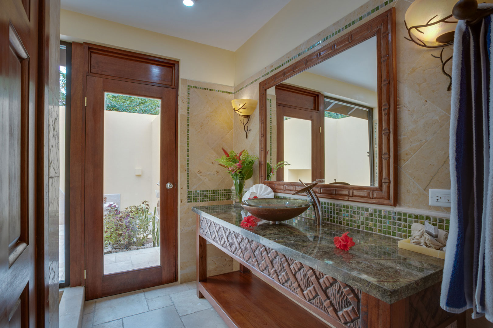 The master bathroom with a walk in shower, sink and large vanity mirror inside the Riverview Room at The Rainforest Lodge at Sleeping Giant